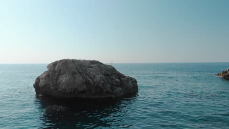 Disparo-De-Un-Dron-Bajo-Alrededor-De-La-Roca-Marina-En-Un-Día-Soleado