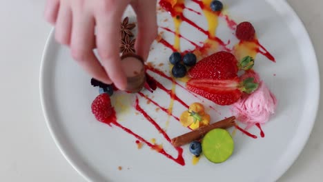 Lady-reaching-for-a-chocolate-from-an-elegant-dessert-platter