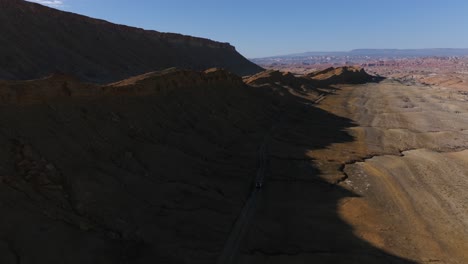 Driving-along-Martian-like-road-of-Factory-Butte-in-Utah,-USA