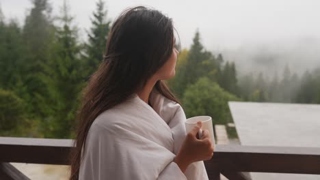 woman enjoying a morning drink with a mountain view