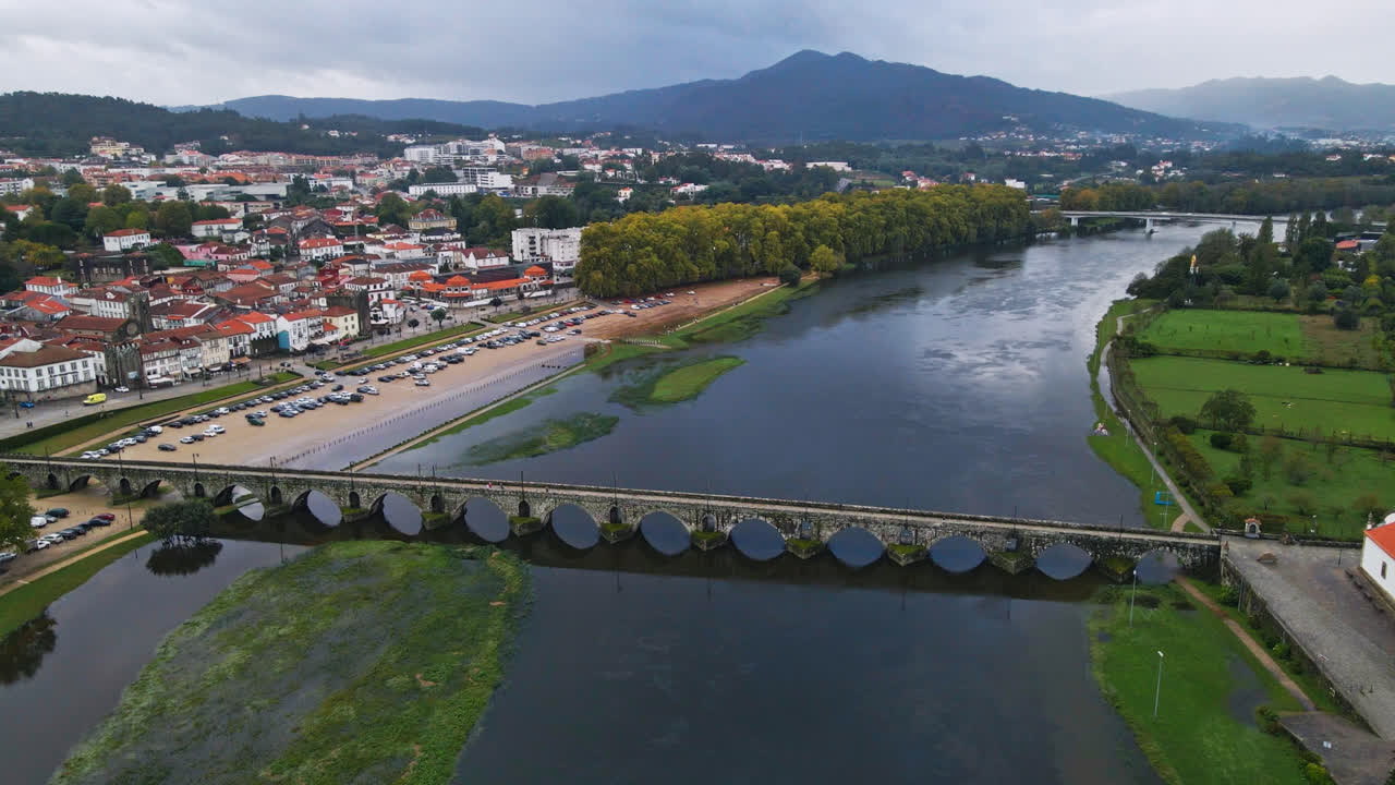 impresionantes imágenes aéreas en 4k de un pueblo - ponte de lima en portugal y su punto de referencia icónico - puente romano de piedra que cruza el río lima