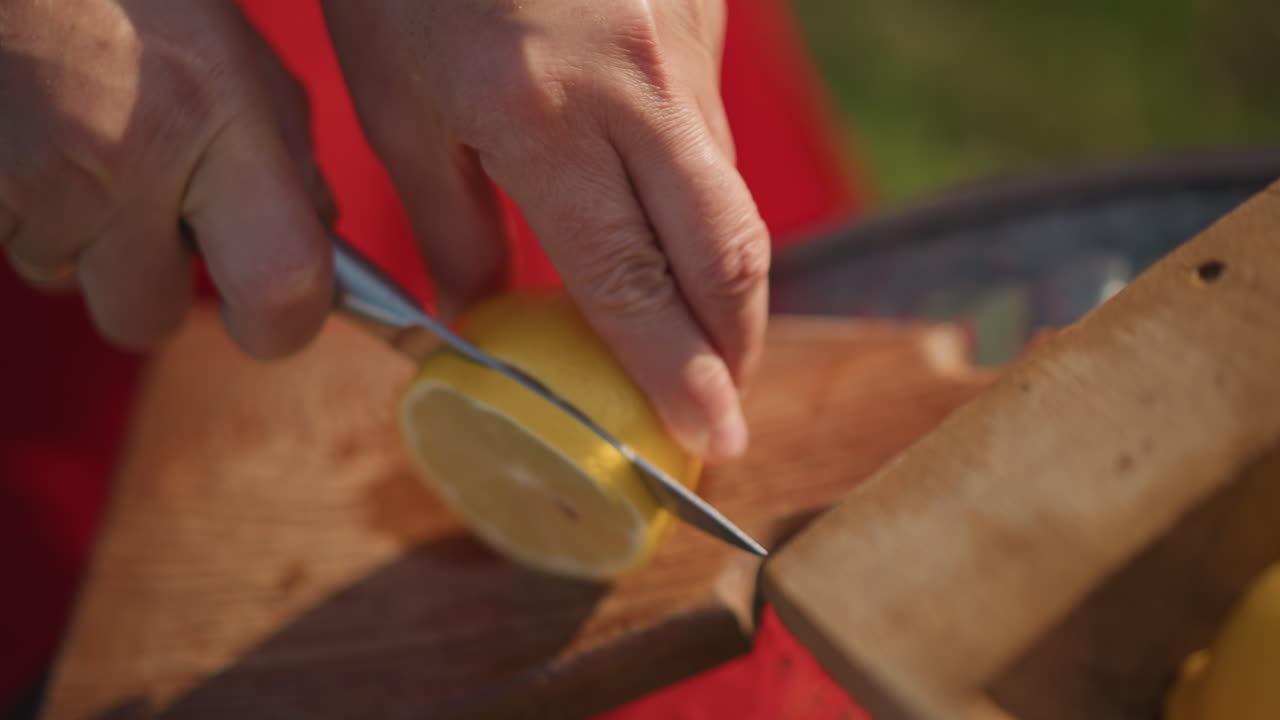 Limón cortado para bebida. Primer plano de la preparación de limón para bebida. Chef rebanando cuidadosamente el limón para adorno de bebida fresca. Vista detallada del chef preparando rodajas de limón para decoración de bebidas.
