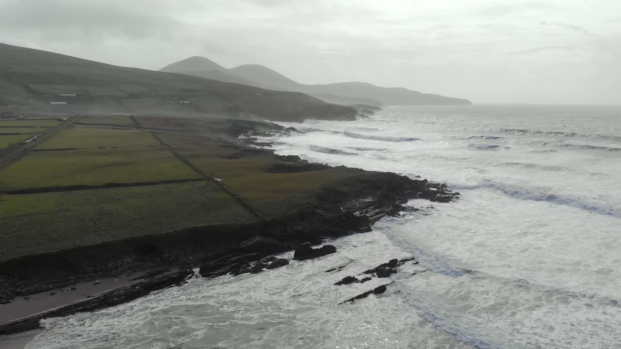 antena del paisaje marino atlántico junto a la playa de arena, olas y rocas negras