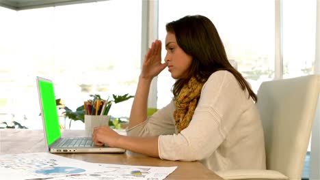 una chica bonita concentrándose en su portátil.