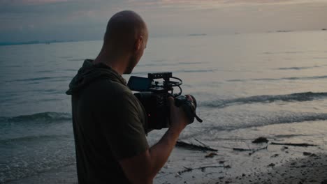 videographer filming sunset at the beach
