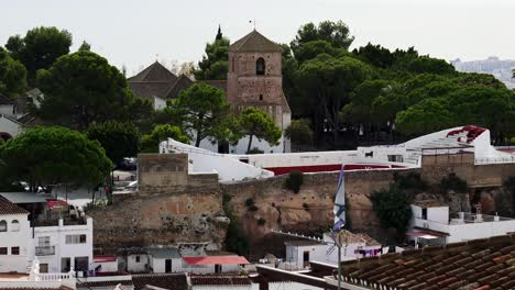 zoomed in shot of the church tower of mijas and the historic bull fighting ring of this old white town. costa del sol, spain
