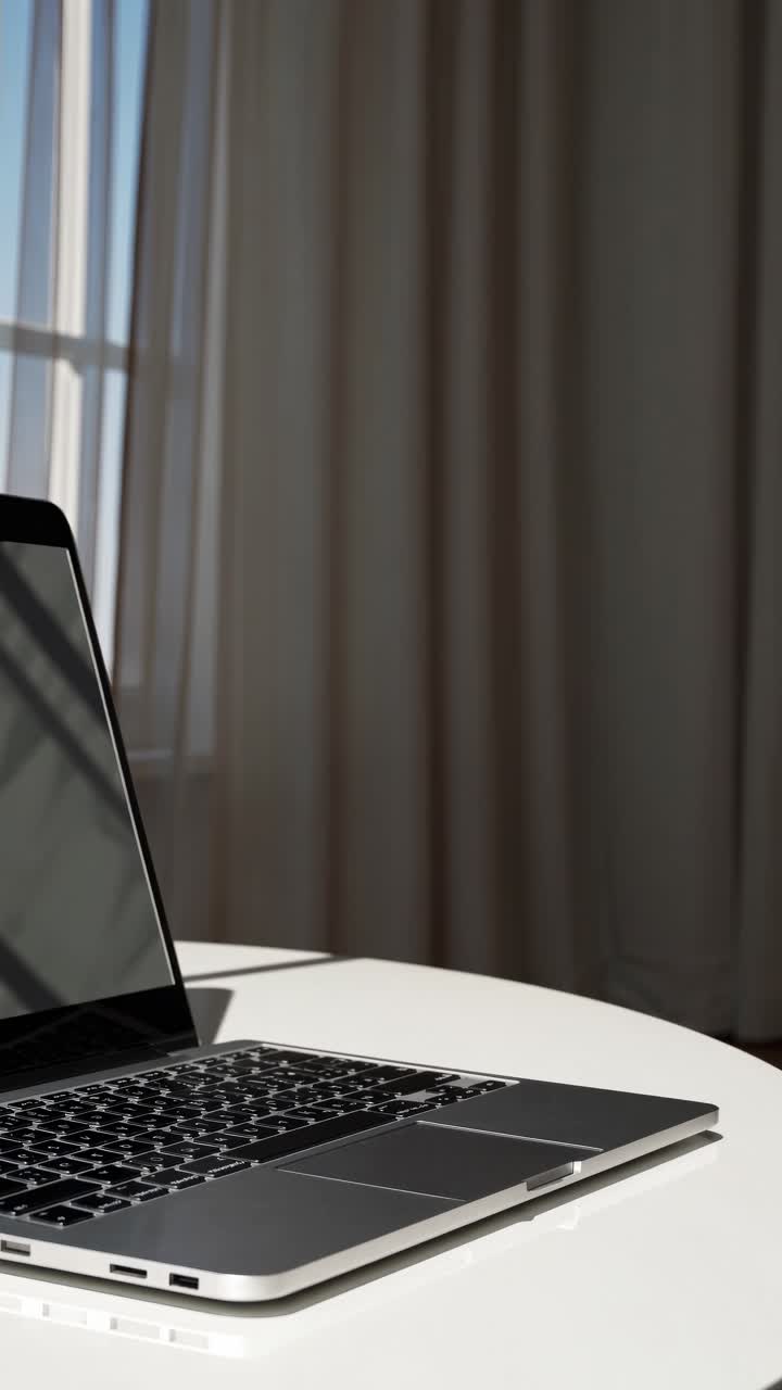 Un video concept minimalista con un laptop su un tavolo bianco. Scatto da un angolo basso