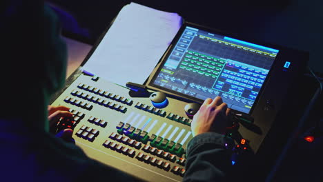 técnico de iluminación que opera la consola