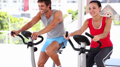 pareja en forma trabajando en bicicletas de ejercicio