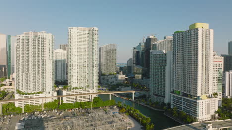 Volar-Por-Encima-De-La-Ciudad.-Dirigiéndose-Hacia-Un-Moderno-Complejo-De-Edificios-De-Apartamentos-De-Gran-Altura-A-Lo-Largo-Del-Río.-Escena-De-La-Hora-Dorada.-Miami,-Estados-Unidos