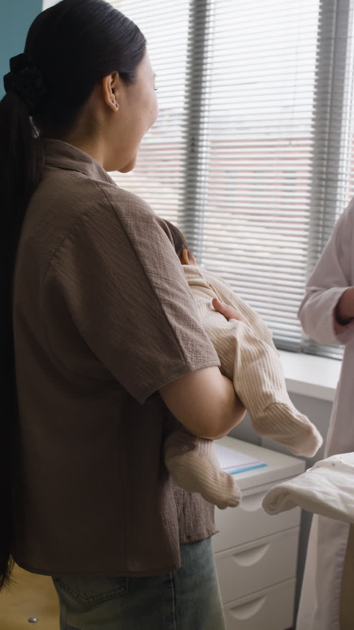 Doctor examining baby with mother present