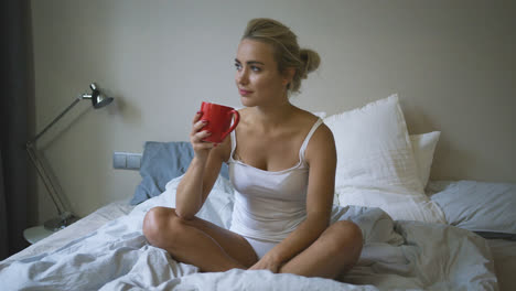 Woman-in-underwear-drinking-on-bed