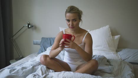 Woman-in-underwear-drinking-on-bed