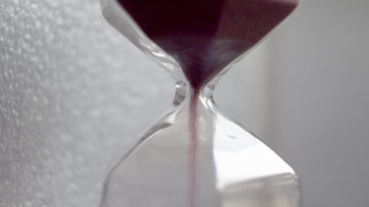Extreme Close Up View Of Pink Sand Particles Flowing Through An Hourglass