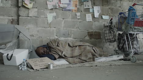 homeless person sleeping on a sidewalk with personal belongings