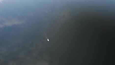 Aerial-high-altitude-orbit-over-a-lonely-yacht-sailing-on-the-calm-dark-waters-in-northern-Europe