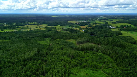 Lush-green-forests-and-farmlands-in-the-countryside-under-a-partly-cloudy-sky