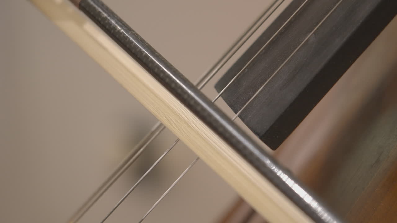 Primo piano di una mano che suona uno strumento a corda con l'archetto