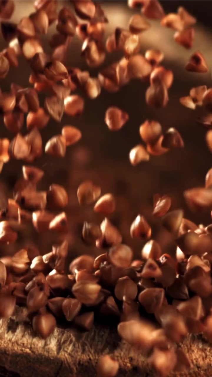 Primo piano di grani di grano saraceno crudo che cadono al rallentatore
