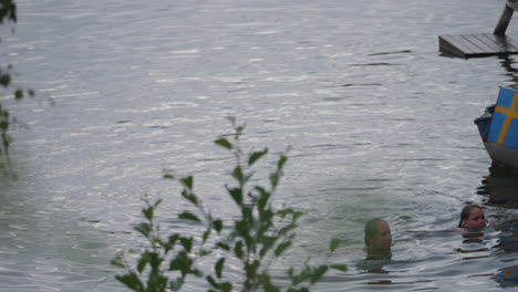 Madre-E-Hija-Nadando-En-Un-Lago-Disfrutando-En-El-Norte-De-Suecia