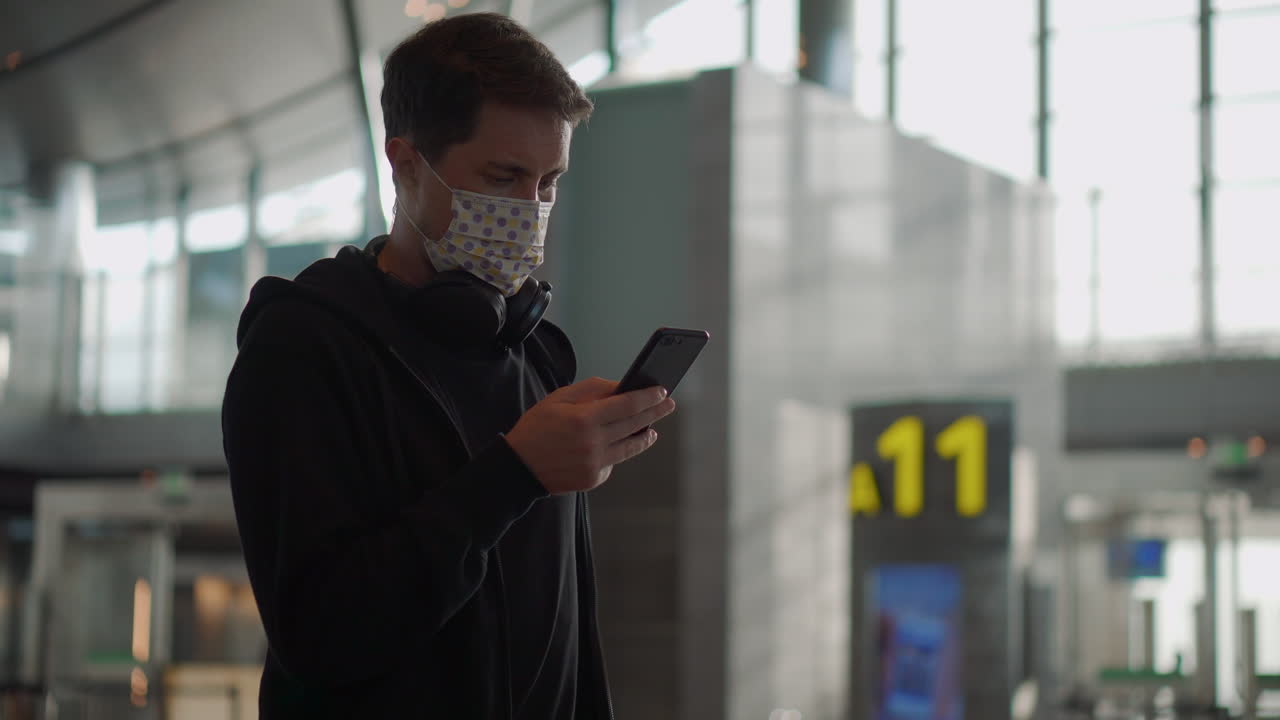 hombre usando teléfono inteligente en el aeropuerto