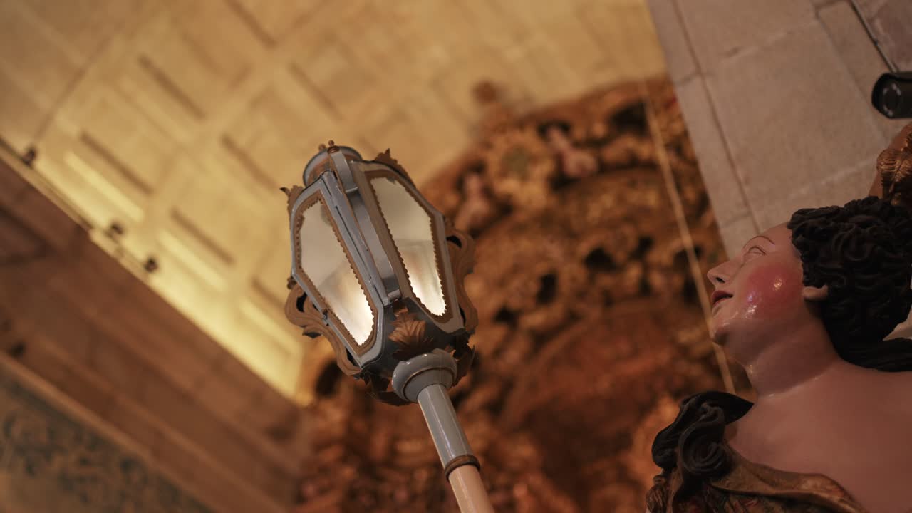 church lantern and statue beneath golden baroque ceiling detail