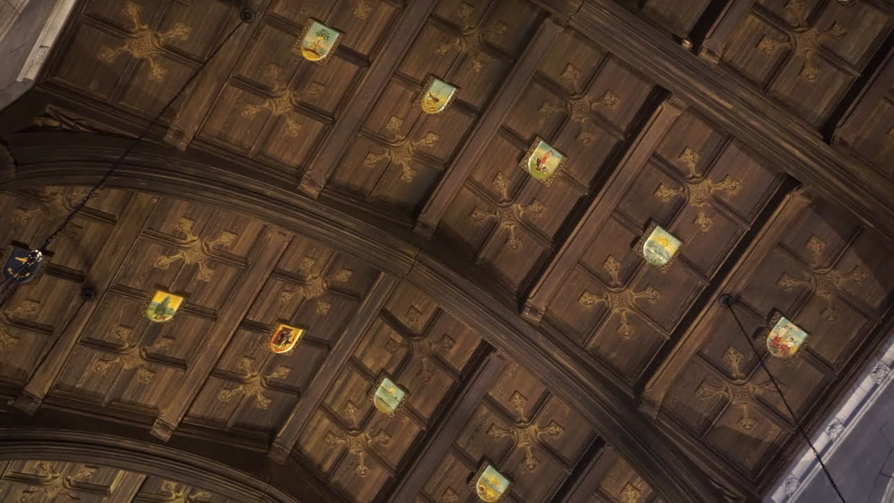 Arched wood paneled ceiling with heraldry and floral cruciform patterns