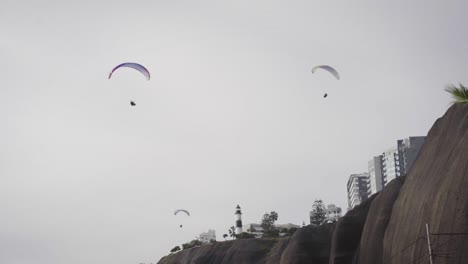 Parapentes-Sobrevolando-La-Costa-Verde,-Lima,-Perú