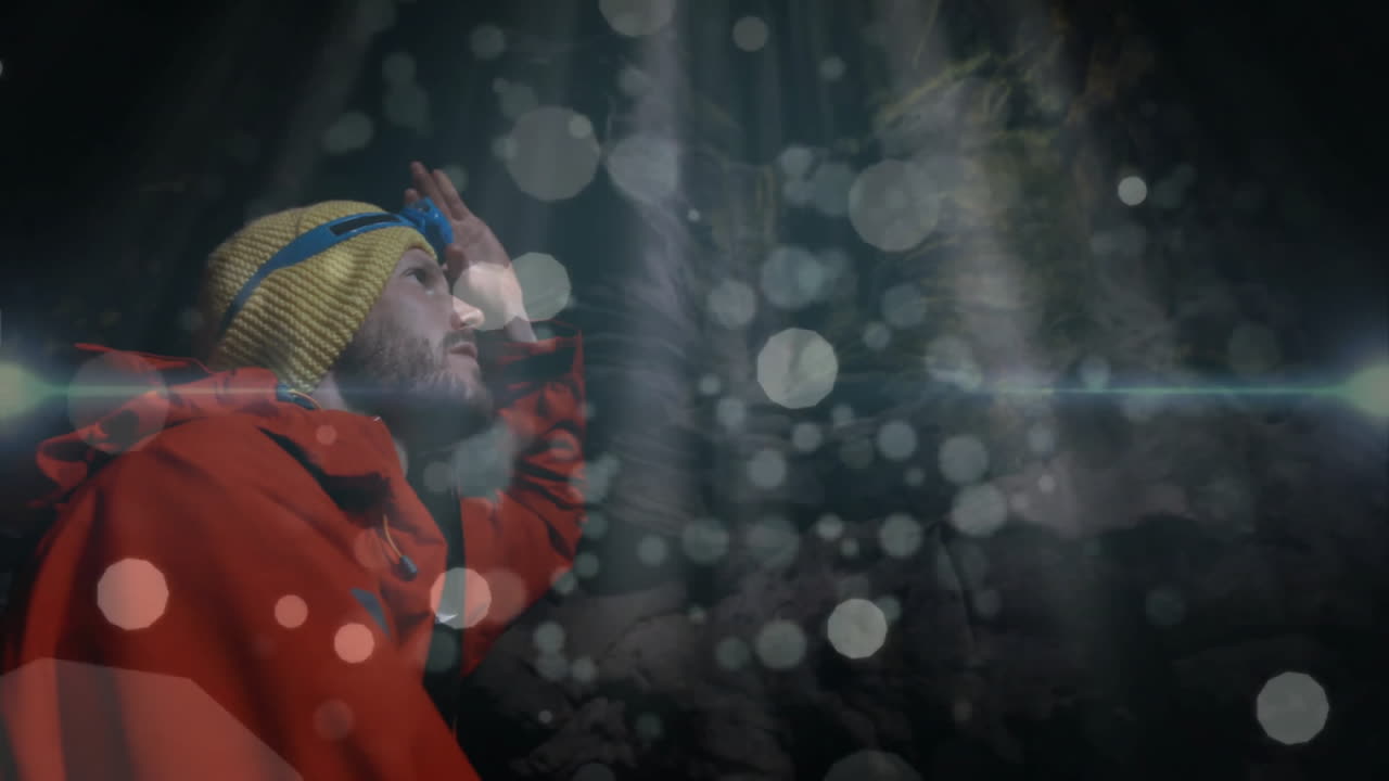Mountaineer adjusting headlamp inside cave, showing dust particles with animated tech overlays
