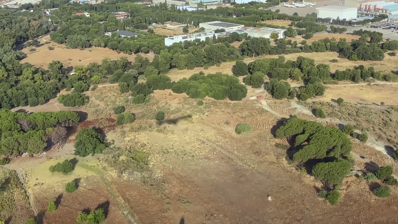 An aerial cockpit view of the shadow of a jet airplane on short final to Madrid airport in a hot summer morning
