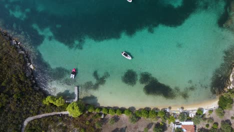 Overhead-Drohne-Clip-Einer-Kleinen-Tropischen-Inselbucht-Mit-Kristallblauem-Wasser-Und-Luxuriösen-Booten-In-Der-Gegend-Von-Vourvourou,-In-Nordgriechenland-Chalkidiki-In-4k