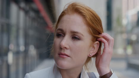 close up portrait attractive young red head business woman running hand through hair enjoying relaxed urban lifestyle slow motion