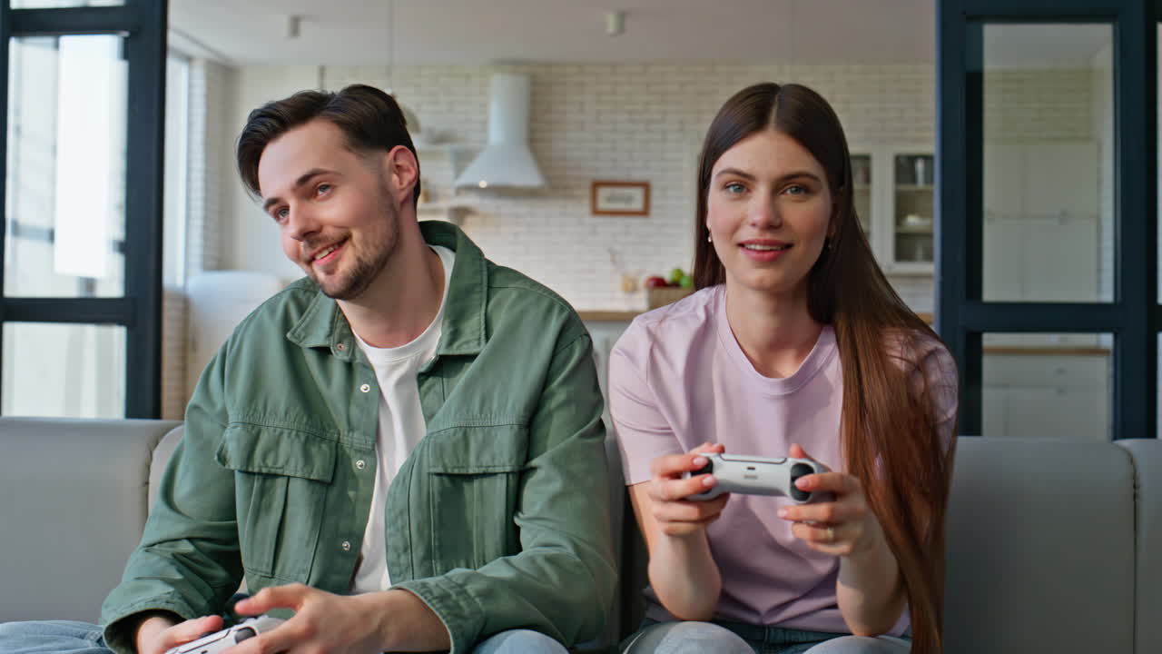 Emotional pair pressing console buttons playing video game at home sofa closeup