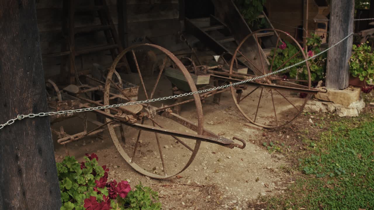 Rusty antique wagon wheels on display outside a shed in Kumrovec, Croatia