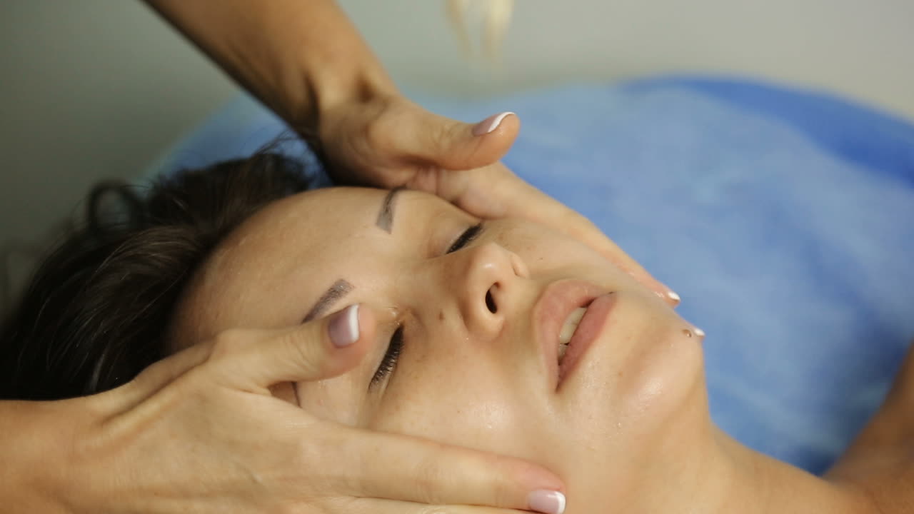 Spa face massage. Young beautiful girl having face massage relaxing in spa salon