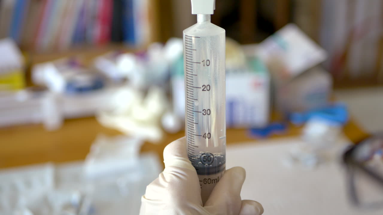 Medical syringe held by gloved hand