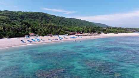 Luftaufnahme-Eines-Wunderschönen-Sandstrandes,-Klares-Karibisches-Meerwasser-Mit-Korallenriff-Und-Grünen-Bergen-Im-Hintergrund---Barahona,-Dominikanische-Republik