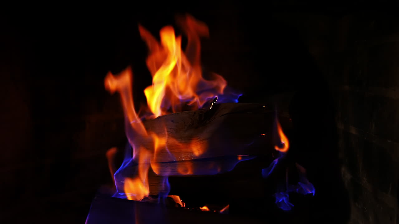 Roaring flames in modern fireplace. Glowing fire in a huge stone fireplace