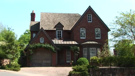 beautiful landscaping including trailing ivy arching over the garage door add to the country charm of this twostory brick home