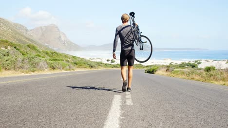 triathlete man carrying cycle in the countryside road