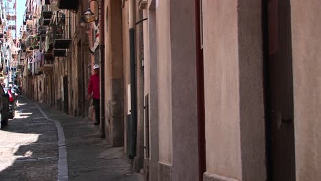 An-alley-between-closely-placed-houses-with-clothes-drying-from-balconies-and-staircases-in-Cefalu-Italy---