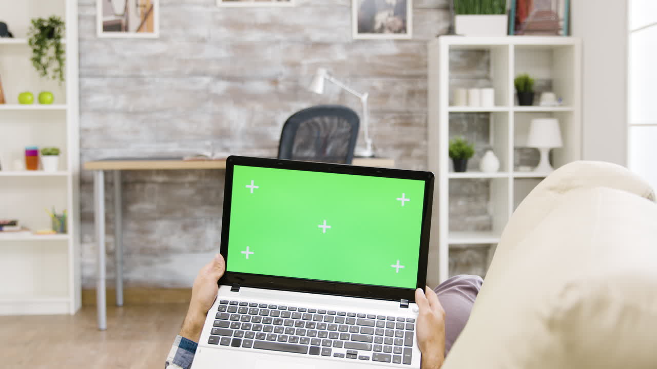 persona que utiliza una computadora portátil con una pantalla verde