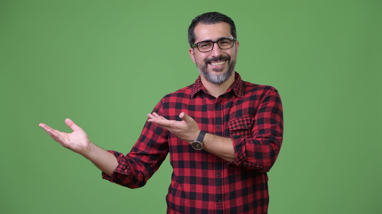 Handsome Persian bearded man showing something
