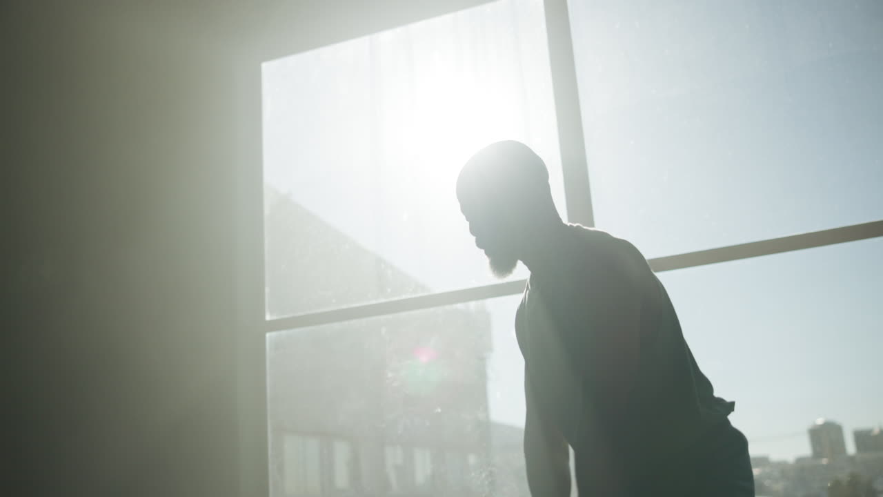 Man exercising with kettlebell in front of window
