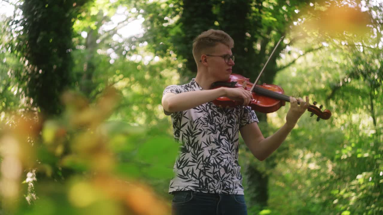 hermosa actuación de música al aire libre de un joven caucásico tocando el violín