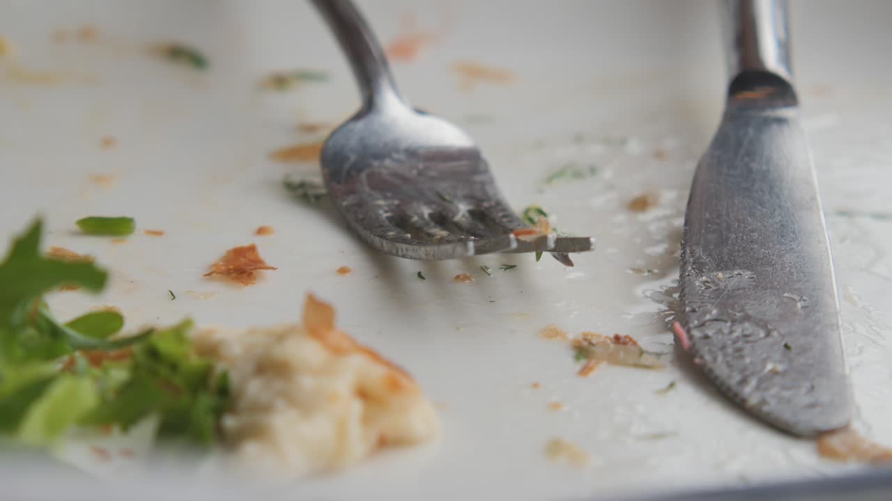 plato vacío con utensilios y sobras