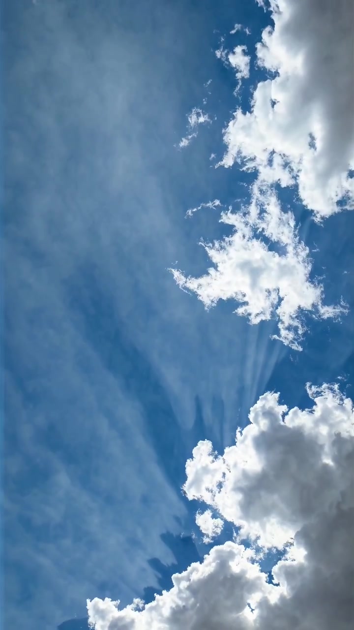 Raggi di sole che filtrano attraverso le nuvole nel cielo blu