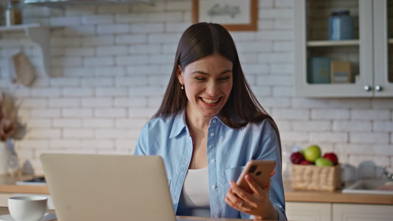 Businesswoman hand checking smartphone at computer table remote office closeup