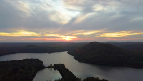 cielo dorado de la puesta de sol sobre el interminable paisaje forestal y las montañas, vista aérea