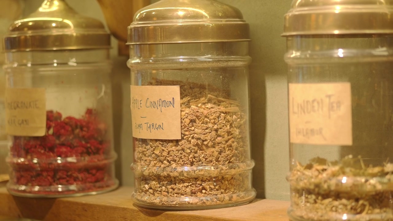 Barattoli di vetro riempiti con erbe aromatiche e spezie essiccate su uno scaffale